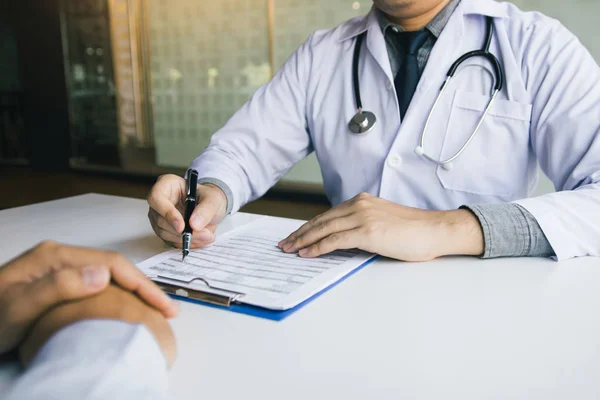 Médico de mano sosteniendo la pluma y hablando con el paciente sobre medicat — Foto de Stock