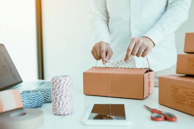 Genç Asyalı ergen mal sahipleri küçük işletme babalarını paketliyorlar.