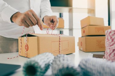 Genç Asyalı ergen mal sahipleri küçük işletme babalarını paketliyorlar.