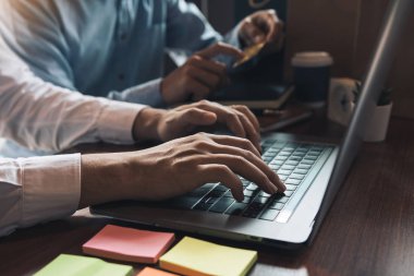 Bir grup arkadaş birlikte dizüstü bilgisayardaki ürünlere bakıyorlar.