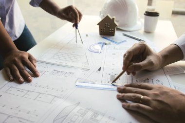 Taslak üzerinde çalışan mimar yeni projeyi colle ile tartışıyor