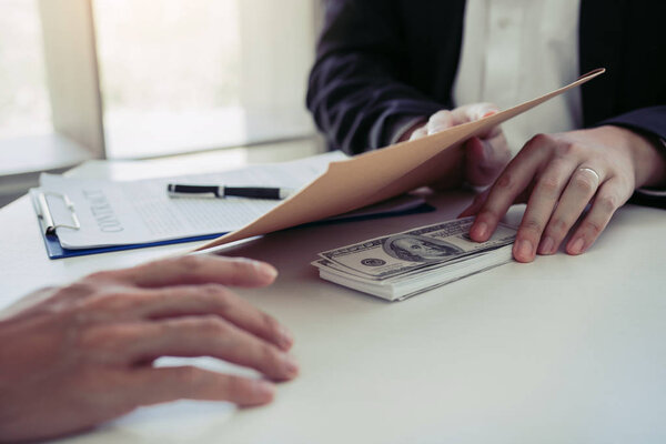 Бизнесмен тайно дает взятку, давая деньги счета в env
