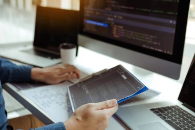 Asyalı adam kod programı geliştiricisi bilgisayar geliştirme web tasarım yazılımı ofiste masa üzerinde çalışıyor.