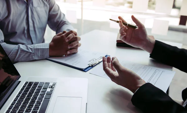 Yöneticinin karşısında masa başında oturan Asyalı genç bir yetişkin iş görüşmesine katılıyor..