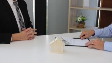Ev satış temsilcileri ve alıcılar yeni evler imzalamak ve el sıkışmak için çalışıyorlar..