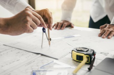 İki mühendislik birlikte çalışma ve masa üzerinde mimari plan ile pusula görünümlü plan ve analiz kullanarak.