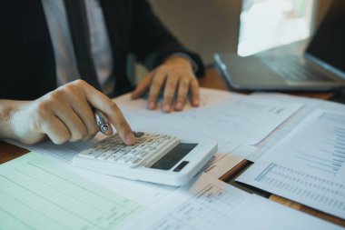 İşadamları şirketin satış maliyetinin hesaplanması ve ofiste grafik analiz.