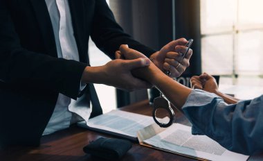 Polis şüpheliyi tutukladı ve suçlamayı kabul etmesi için kelepçeledi..