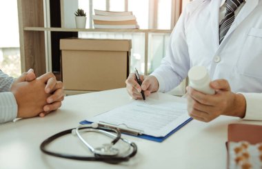 Veri bilgileri için not defteri ve dizüstü bilgisayara kalem yazan Asyalı bir doktor..