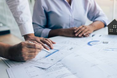 Takım mimarı ya da mühendisleri bir inşaat sahasında masada birlikte çalışmayı tartışıyorlar..