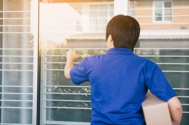 Genç Asyalı kurye malları teslim etmek için kapıyı çalıyor..