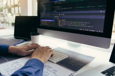 Asyalı adam kod programı geliştiricisi bilgisayar geliştirme web tasarım yazılımı ofiste masa üzerinde çalışıyor.
