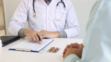 Doktor klinikteki yaşlı hastayla el sıkışıyor..