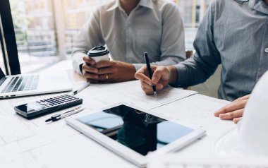 İki mühendislik birlikte çalışan ve dijital tablet seyir planı ve analiz mimari plan üstünde okul sırası ile kullanma.