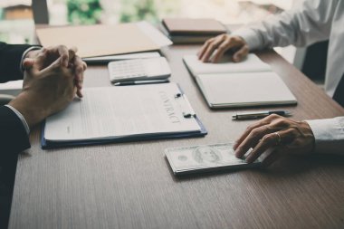 Ortak, satış sözleşmesinde bir sahtekarlık yaptı ve iş adamına rüşvet konseptini imzalayan bir para ve kalem uzattı..