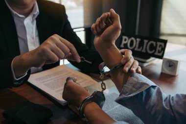 Polis şüpheliyi tutukladı ve suçlamayı kabul etmesi için kelepçeledi..