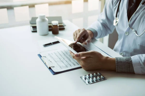 Asian doctor using the tablet explaining the patient condition and the treatment result.