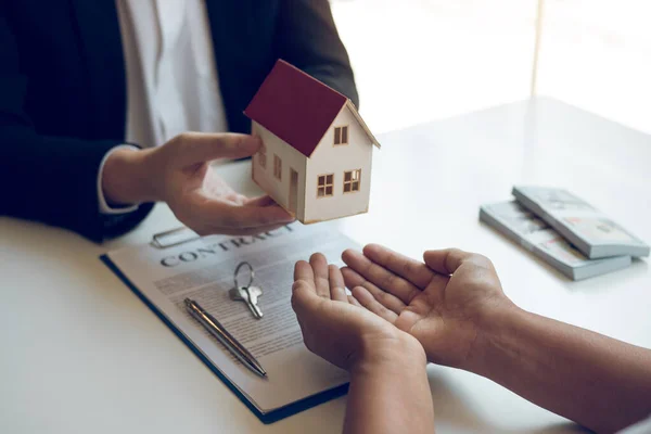 New home buyers are signing a home purchase contract at the agent's desk.
