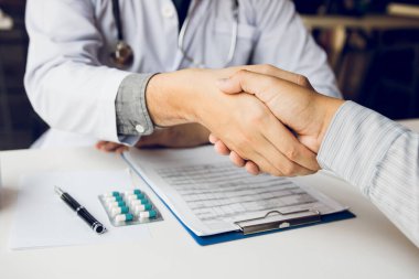 Doktor klinikteki yaşlı hastayla el sıkışıyor..