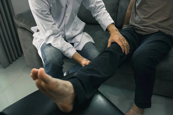 理学療法士は 患者の太ももをグリップするために手を使用しているクリニックでの痛みやマッサージをチェックする — ストック写真
