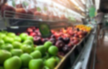 Süpermarkette alışveriş perakendecisinde raflarda sebze ve meyve bulanıklığı.