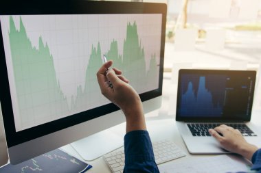 El yatırımcıların Yakın yatırım bilgileri hisse senedi piyasaları ve ortaklar notlar alarak ve performans verilerini analiz dizüstü bilgisayar işaret ediyor.