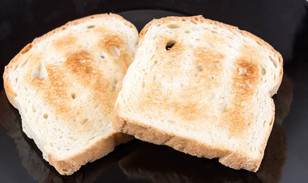 Duas fatias de grãos inteiros de pão torrado em uma placa de cerâmica — Fotografia de Stock