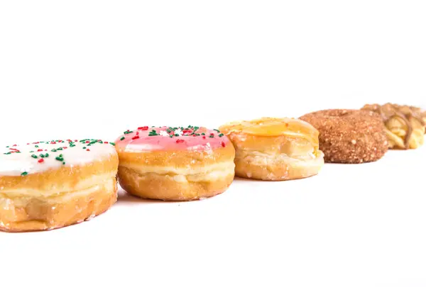 Frosted Donut Lineup flache Schärfentiefe — Stockfoto