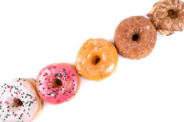 Frosted Donut Lineup flache Schärfentiefe — Stockfoto