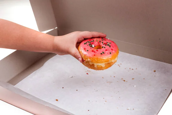 Kinderhand stiehlt den letzten Donut aus der Schachtel — Stockfoto