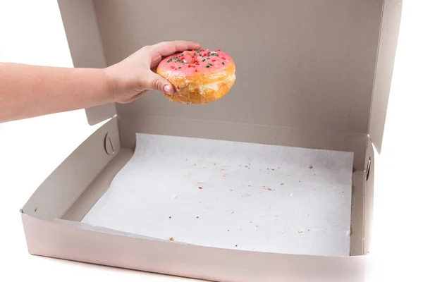 Kinderhand stiehlt den letzten Donut aus der Schachtel — Stockfoto