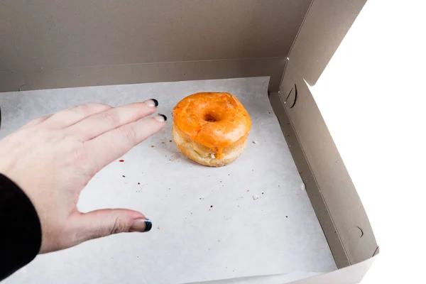 Erwachsene Hand stiehlt den letzten Donut — Stockfoto