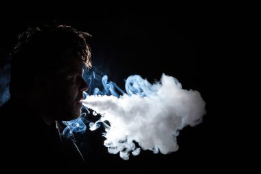 Karanlık, arkadan aydınlatmalı bir adam vaping profil görünümü