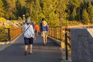 İnsanlar gece ışığında Tahoe Gölü 'nün yakınındaki yürüyüş parkurunda geziyorlar.