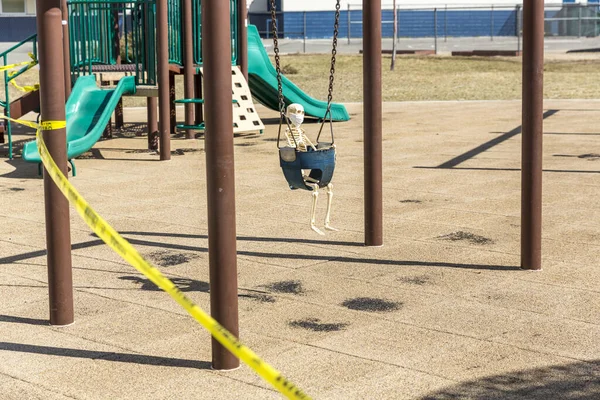 Skeleton Child Swinging Baby Seat Wearing Mask Empty Closed Park — Stock Photo, Image