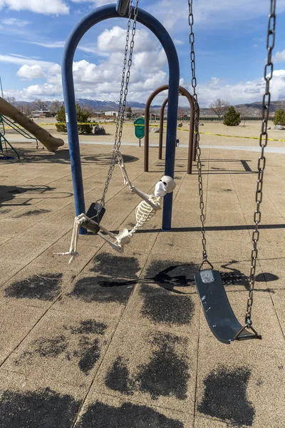 Skeleton Swinging Childs Toy Wearing Mask Empty Closed Park Nice — Stock Photo, Image