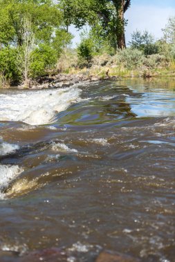 Nehrin akışı kayaların üzerinden akarken yansımaları var.