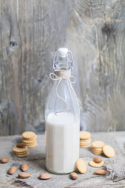 Поживне мигдальне горіхове молоко в скляній пляшці на сільській старовинній волі — стокове фото