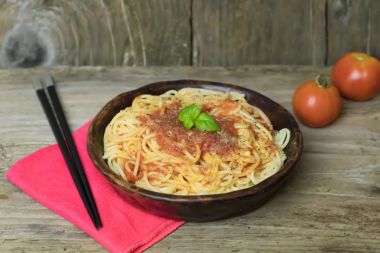 Spagetti makarna makarna sos domates ve fesleğen rustik yandan ile seramik tabak üzerinde eski ahşap masa hazırladım..