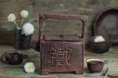 Çay molası zamanı. El yapımı antika seramik çaydanlık çaydanlık üstünde o eski rustik ahşap masa üzerinde Çince kelime demir ile kare. Çin çay töreni. Asya geleneksel kültür.