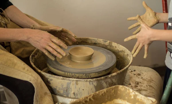 Close Up Of Mature Potter Hands Which Guide And Help child Make A Clay Pot On The Potters Wheel, Master Class Or Teamwork Concept. Selectiva focus. — Stock Photo, Image