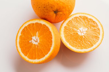 dilimlenmiş portakal yarısı ve bütün beyaz arka plan portre üzerinde