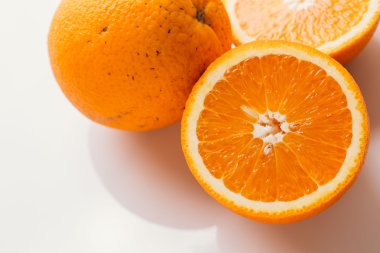 dilimlenmiş portakal yarısı ve bütün beyaz arka plan portre üzerinde