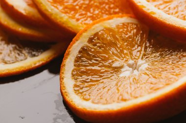 koyu arka plan portre üzerinde turuncu yarım dilimlenmiş