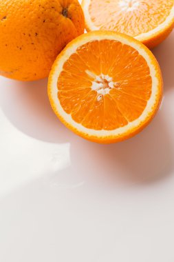 dilimlenmiş portakal yarısı ve bütün beyaz arka plan portre üzerinde