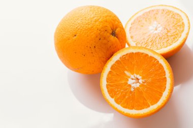 dilimlenmiş portakal yarısı ve bütün beyaz arka plan portre üzerinde