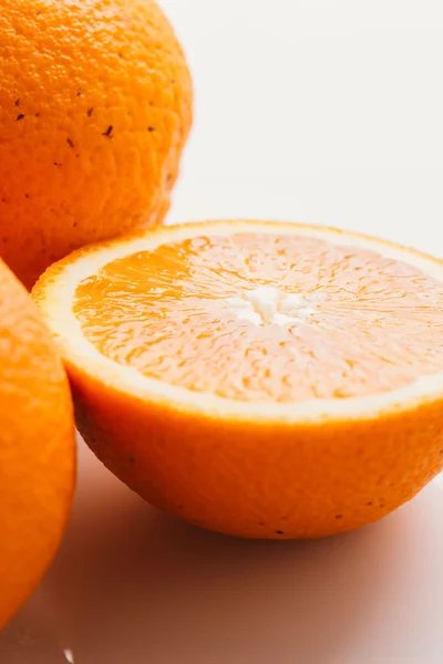 dilimlenmiş portakal yarısı ve bütün beyaz arka plan portre üzerinde