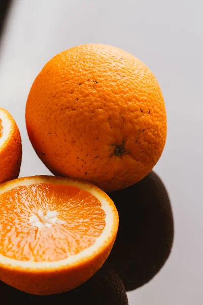 dilimlenmiş portakal yarısı ve bütün koyu arka planı portre üzerinde