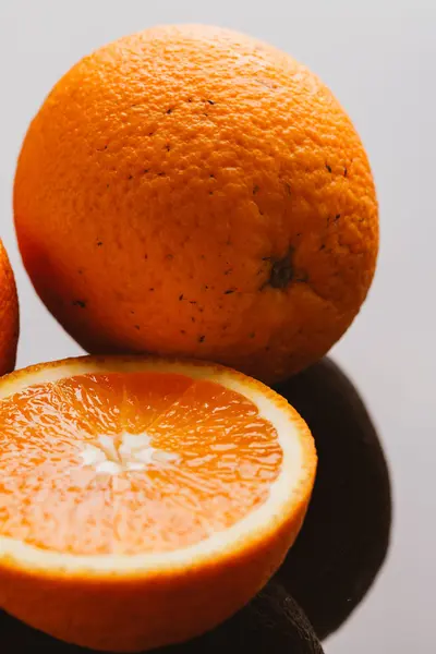 dilimlenmiş portakal yarısı ve bütün koyu arka planı portre üzerinde