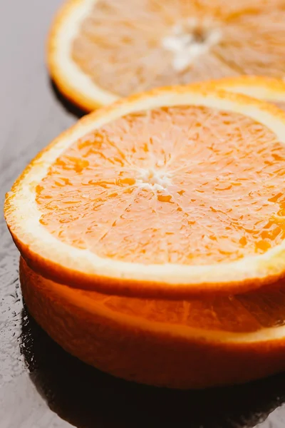 koyu arka plan portre üzerinde turuncu yarım dilimlenmiş